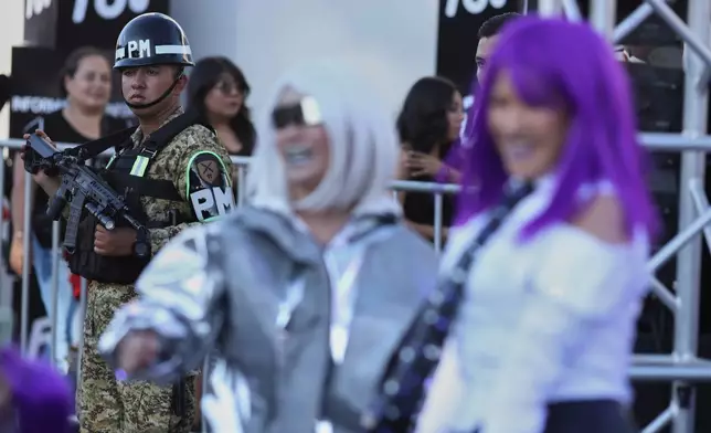 A soldier stands by fans of Colombian pop star Shakira before her concert at the National Stadium in San Salvador, El Salvador, Thursday, Feb. 12, 2026. (AP Photo/Salvador Melendez)