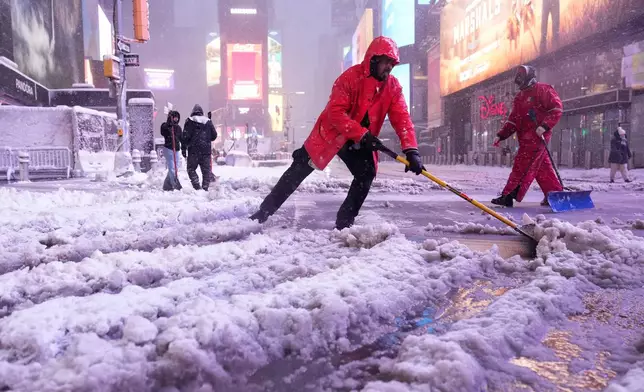 A worker with the Times Square Alliance sanitation crew shovels snow in Times Square, Monday, Feb. 23, 2026, in New York. (AP Photo/Seth Wenig)