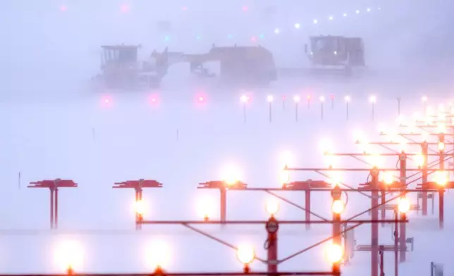 Snowplows clear a runway at Manchester-Boston Regional Airport during a winter storm, Monday, Feb. 23, 2026, in Londonderry, N.H. (AP Photo/Charles Krupa)