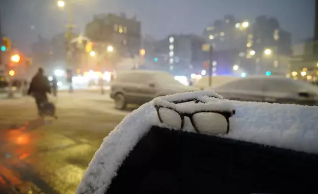 A pair of missing glasses sits in accumulated snow on top of a mailbox during a snowstorm, Sunday, Feb. 22, 2026, in New York. (AP Photo/Pamela Hassell)