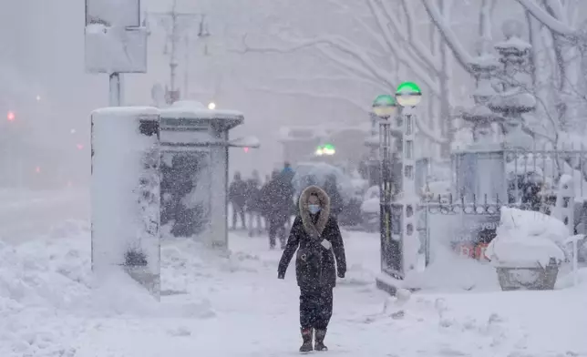 A pedestrian walks along 42nd Street near Bryant Park during a snow storm, Monday, Feb. 23, 2026, in New York. (AP Photo/Seth Wenig)