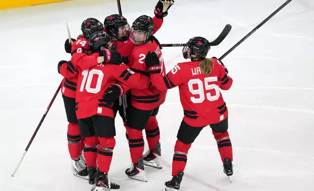 Canada's Marie-Philip Poulin, third from left, celebrates after scoring a goal against Switzerland during the second period of a women's ice hockey semifinal match at the 2026 Winter Olympics, in Milan, Italy, Monday, Feb. 16, 2026. (AP Photo/Carolyn Kaster)