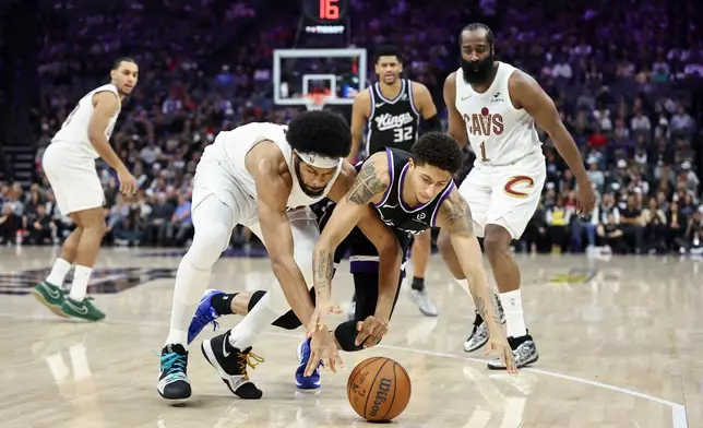 Sacramento Kings guard Nique Clifford (5) and Cleveland Cavaliers center Jarrett Allen, left, dive for a loose ball during the first half of an NBA basketball game Saturday, Feb. 7, 2026, in Sacramento, Calif. (AP Photo/Sara Nevis)
