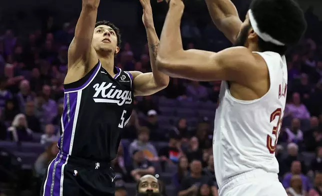 Sacramento Kings guard Nique Clifford (5) takes a shot over Cleveland Cavaliers center Jarrett Allen, right, during the first half of an NBA basketball game Saturday, Feb. 7, 2026, in Sacramento, Calif. (AP Photo/Sara Nevis)