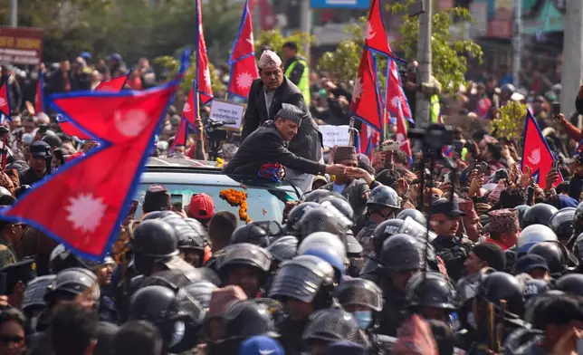 Former King Gyanendra Shah receives flowers from supporters upon his arrival at Tribhuvan International Airport in Kathmandu, Nepal, Friday, Feb. 13, 2026. (AP Photo/Niranjan Shrestha)