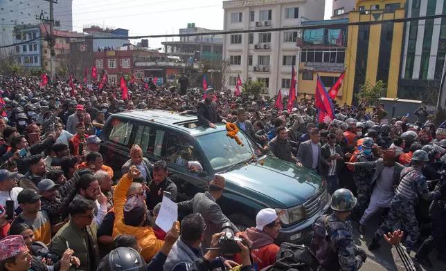 Supporters gather to welcome Nepal's former King Gyanendra Shah, center, upon his arrival at Tribhuvan International Airport in Kathmandu, Nepal, Friday, Feb. 13, 2026. (AP Photo/Niranjan Shrestha)