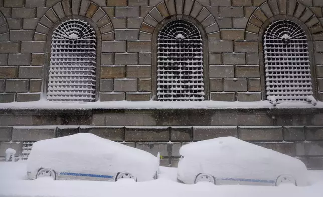 City vehicles sit parked covered in snow in lower Manhattan during a snow storm, Monday, Feb. 23, 2026, in New York. (AP Photo/Seth Wenig)
