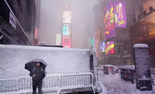 A man pauses while walking through Times Square during a snow storm, Monday, Feb. 23, 2026, in New York. (AP Photo/Seth Wenig)