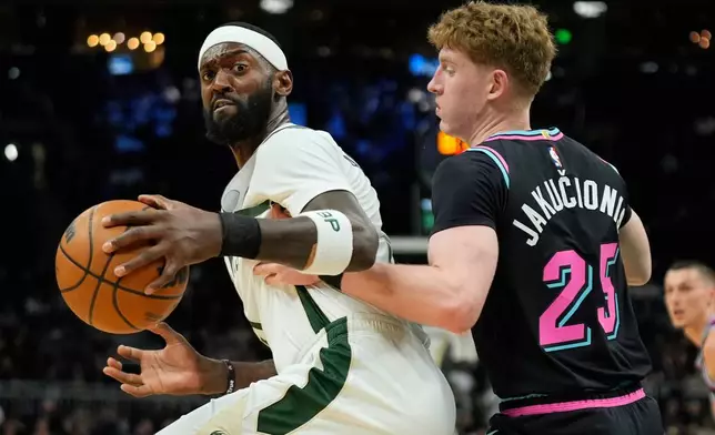Milwaukee Bucks' Bobby Portis, left, drives to the basket against Miami Heat's Kasparas Jakučionis during the first half of an NBA basketball game Tuesday, Feb. 24, 2026, in Milwaukee. (AP Photo/Aaron Gash)