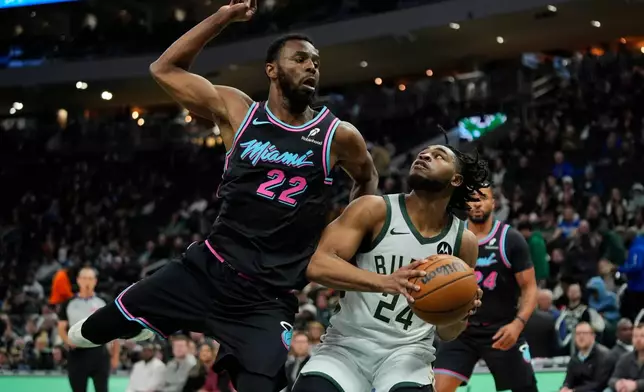 Milwaukee Bucks' Cam Thomas (24) looks to shoot past Miami Heat's Andrew Wiggins during the first half of an NBA basketball game Tuesday, Feb. 24, 2026, in Milwaukee. (AP Photo/Aaron Gash)
