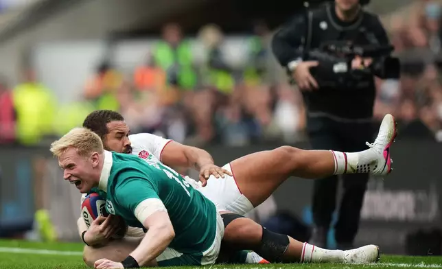 Ireland's Jamie Osborne, front, is tackled by England's Ollie Lawrence during the Six Nations rugby union match between England and Ireland in London, England, Saturday, Feb. 21, 2026. (AP Photo/Alastair Grant)