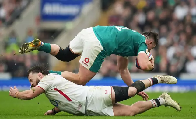 Ireland's Dan Sheehan, top, avoids a tackle by England's Luke Cowan-Dickie during the Six Nations rugby union match between England and Ireland in London, England, Saturday, Feb. 21, 2026. (AP Photo/Alastair Grant)