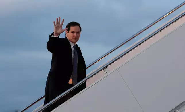 Secretary of State Marco Rubio waves as he boards his plane, Thursday, Feb. 12, 2026, at Joint Base Andrews, Md., en route to the Munich Security Conference. (AP Photo/Alex Brandon, Pool)