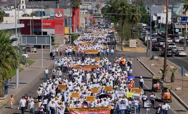 Relatives and friends of 10 mine workers who were abducted last month in neighboring Sinaloa state, march demanding justice, in Hermosillo, Mexico, Saturday, Feb. 14, 2026. (AP Photo/Luis Gutierrez)