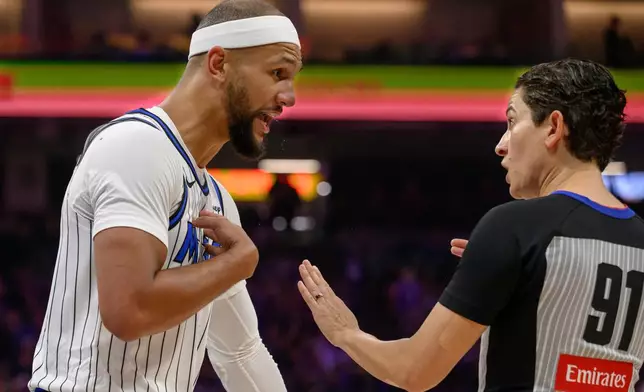 Orlando Magic guard Jalen Suggs, left, argues with referee Che Flores, right, during the first half of an NBA basketball game against the Sacramento Kings in Sacramento, Calif., Thursday, Feb. 19, 2026. (AP Photo/Randall Benton)