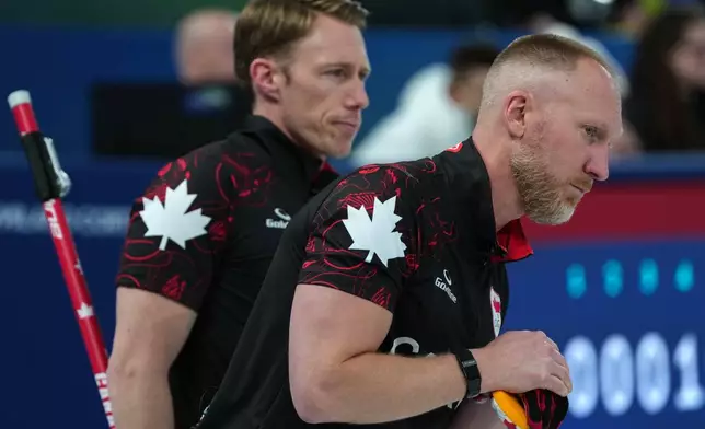 Canada's Brad Jacobs and Marc Kennedy in action during the men's curling round robin session against Sweden, at the 2026 Winter Olympics, in Cortina d'Ampezzo, Italy, Friday, Feb. 13, 2026. (AP Photo/Misper Apawu)