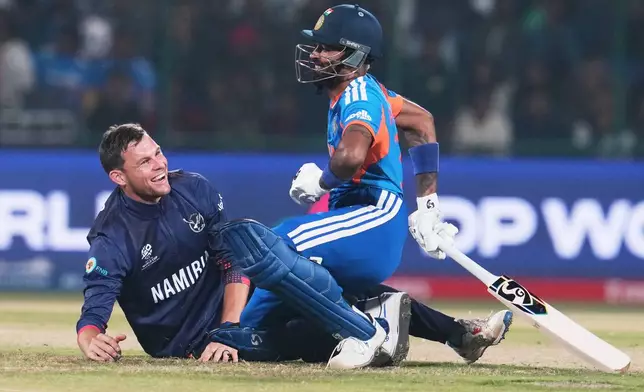 Namibia's captain Gerhard Erasmus, left, and India's Hardik Pandya react after colliding during the T20 World Cup cricket match between India and Namibia in New Delhi, India, Thursday, Feb. 12, 2026. (AP Photo/Manish Swarup)