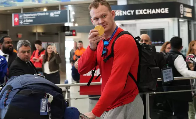 United States' hockey player Brady Tkachuk shows off his goal medal after arriving at Miami International Airport from the Milan Cortina Olympics, Monday, Feb. 23, 2026, in Miami. (AP Photo/Marta Lavandier)