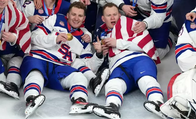 United States' Matthew Tkachuk, left, and Brady Tkachuk pose for the team picture after receiving their gold medals following an overtime win against Canada in the men's ice hockey gold medal game at the 2026 Winter Olympics in Milan, Italy, Sunday, Feb. 22, 2026. (AP Photo/Carolyn Kaster)