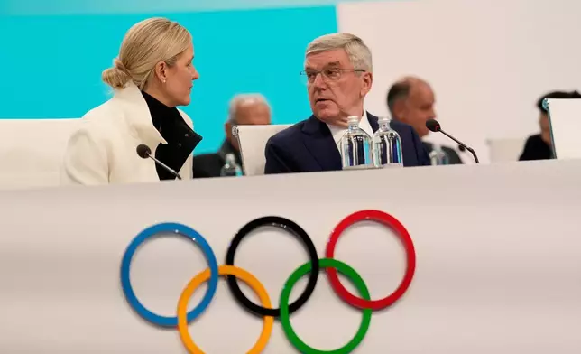 IOC President Kirsty Coventry speaks with former IOC president Thomas Bach, during the opening of the IOC Session, ahead of the 2026 Winter Olympics, in Milan, Italy, Tuesday, Feb. 3, 2026. (AP Photo/Luca Bruno)