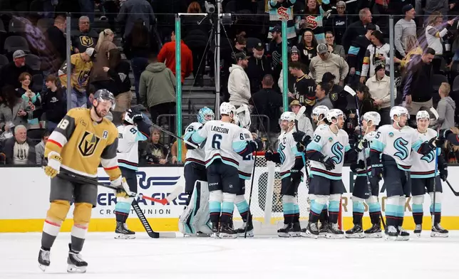 Vegas Golden Knights center Tomas Hertl (48) skates away as members of the Seattle Kraken celebrate a win over the Vegas Golden Knights in an NHL hockey game Saturday Jan. 31, 2026, in Las Vegas. (AP Photo/Steve Marcus)