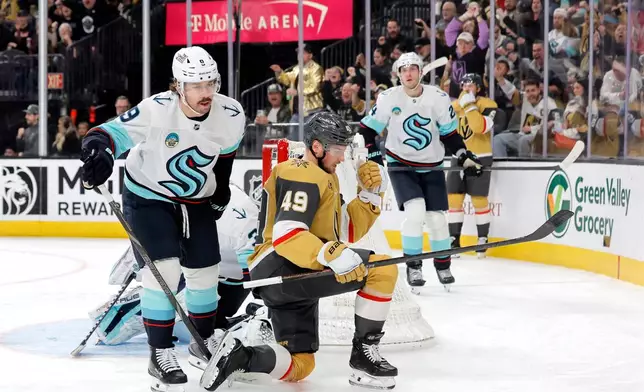 Vegas Golden Knights left wing Ivan Barbashev (49) celebrates in front of Seattle Kraken center Chandler Stephenson (9) after scoring against Kraken goaltender Joey Daccord (obscured) during the second period of an NHL hockey game Saturday Jan. 31, 2026, in Las Vegas. (AP Photo/Steve Marcus)
