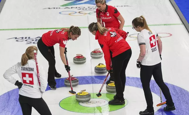 Canada's Emma Miskew, Sarah Wilkes, and Rachel Homan compete against Switzerland's Alina Paetz and Silvana Tirinzoni during the women's curling round robin session at the 2026 Winter Olympics, in Cortina d'Ampezzo, Italy, Saturday, Feb. 14, 2026. (AP Photo/Fatima Shbair)