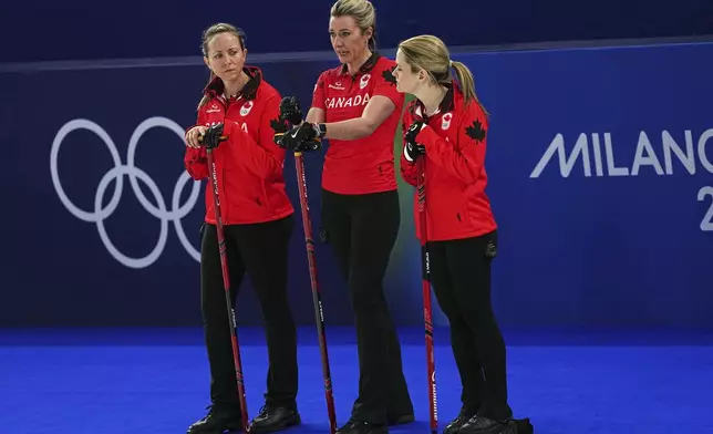 Canada's Rachel Homan, Emma Miskew and Tracy Fleury strategize during the women's curling round robin session against Switzerland at the 2026 Winter Olympics, in Cortina d'Ampezzo, Italy, Saturday, Feb. 14, 2026. (AP Photo/Fatima Shbair)
