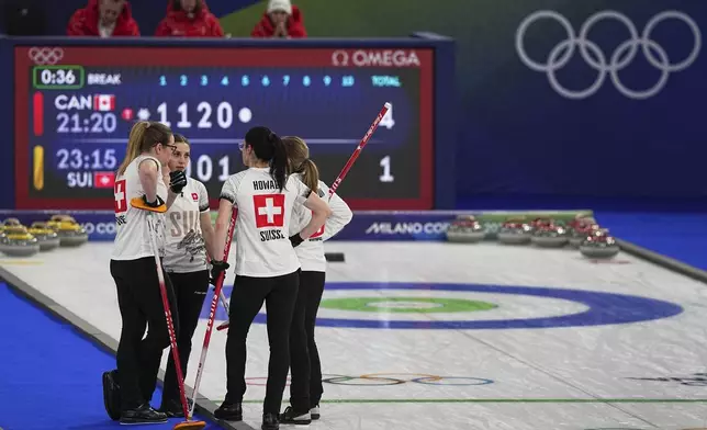 Switzerland's Silvana Tirinzoni, Alina Paetz, Selina Witschonke, and Carole Howald strategize during the women's curling round robin session against Canada at the 2026 Winter Olympics, in Cortina d'Ampezzo, Italy, Saturday, Feb. 14, 2026. (AP Photo/Fatima Shbair)