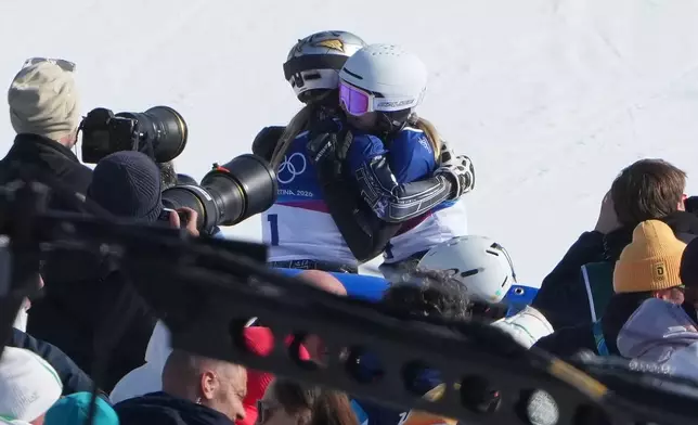 Czechia's Ester Ledecka, left, and Austria's Sabine Payer hug after Payer advanced during the women's snowboarding parallel giant slalom finals at the 2026 Winter Olympics, in Livigno, Italy, Sunday, Feb. 8, 2026. (AP Photo/Lindsey Wasson)