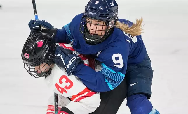 Finland's Nelli Laitinen, right, challenges Canada's Kristin O'Neill during a preliminary round match of women's ice hockey between Finland and Canada at the 2026 Winter Olympics, in Milan, Italy, Thursday, Feb. 12, 2026. (AP Photo/Hassan Ammar)