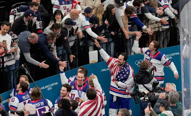 United States players greet fans after defeating Canada in the men's ice hockey gold medal game at the 2026 Winter Olympics, in Milan, Italy, Sunday, Feb. 22, 2026. (AP Photo/Luca Bruno)