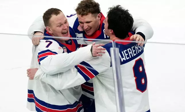 United States' Brady Tkachuk (7), Matthew Tkachuk, center, and Zach Werenski (8) celebrate after their overtime win against Canada in the men's ice hockey gold medal game at the 2026 Winter Olympics in Milan, Italy, Sunday, Feb. 22, 2026. (AP Photo/Carolyn Kaster)