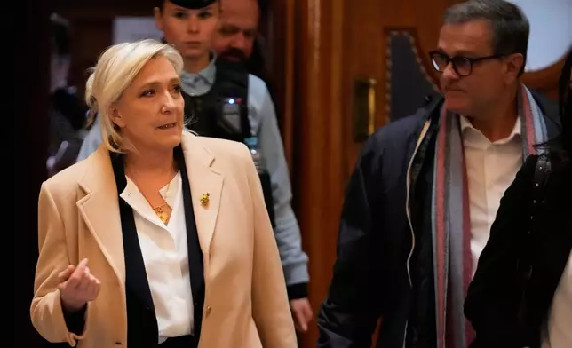 Far-right leader Marine Le Pen walks outside the courtroom during a short break in her appeals trial, in Paris, France, Wednesday, Feb. 11, 2026. (AP Photo/Michel Euler)