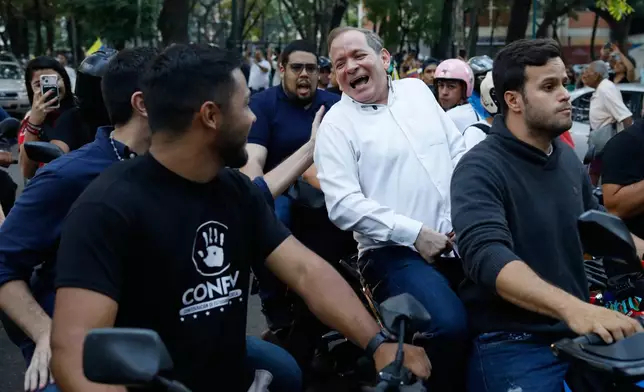 Opposition leader Juan Pablo Guanipa rides on the back of a motorcycle after his release from prison in Caracas, Venezuela, Sunday, Feb. 8, 2026.(AP Photo/Cristian Hernandez)