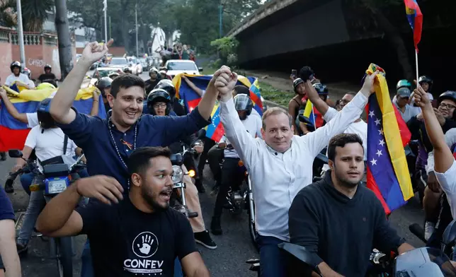 Opposition leader Juan Pablo Guanipa, right, and political activist Jesus Armas ride on the back of motorbikes after their release from prison in Caracas, Venezuela, Sunday, Feb. 8, 2026. (AP Photo/Cristian Hernandez)