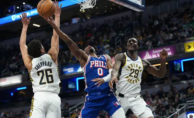 Philadelphia guard Tyrese Maxey (0)shoots between Indiana Pacers defenders Ben Sheppard (26) and Quenton Jackson (29) during the first half of an NBA basketball game in Indianapolis, Tuesday, Feb. 24, 2026. (AP Photo/AJ Mast)