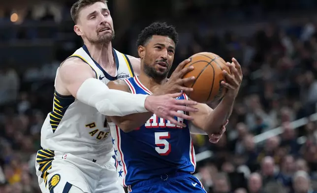 Philadelphia guard Quentin Grimes, right, is fouled by Indiana center Micah Potter during the first half of an NBA basketball game in Indianapolis, Tuesday, Feb. 24, 2026. (AP Photo/AJ Mast)