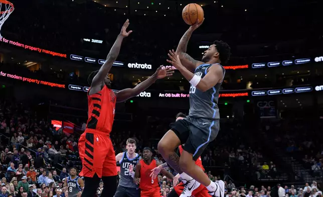 Utah Jazz forward Brice Sensabaugh, right, shoots over Portland Trail Blazers guard Sidy Cissoko, left, during the second half of an NBA basketball game, Thursday, Feb. 12, 2026, in Salt Lake City. (AP Photo/Tyler Tate)