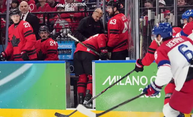 Canada's Sidney Crosby is helped as he leaves the bench after being checked against the boards during the second period of a men's ice hockey quarterfinal game between Canada and Czechia at the 2026 Winter Olympics, in Milan, Italy, Wednesday, Feb. 18, 2026. (AP Photo/Carolyn Kaster)