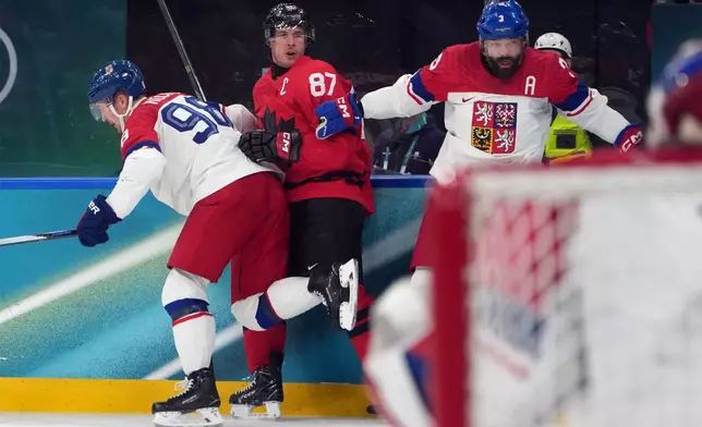 Canada's Sidney Crosby (87) is hit against the boards by Czechia's Martin Necas (98) and Radko Gudas (3) during the second period of a men's ice hockey quarterfinal game at the 2026 Winter Olympics, in Milan, Italy, Wednesday, Feb. 18, 2026. Crosby went to the dressing room after the play. (AP Photo/Carolyn Kaster)