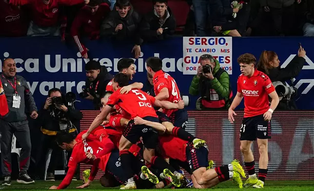 Osasuna's Raul Garcia celebrates with his teammates after scoring his side's second goal during a Spanish La Liga soccer match between Osasuna and Real Madrid in Pamplona, Spain, Saturday, Feb. 21, 2026. (AP Photo/Miguel Oses)
