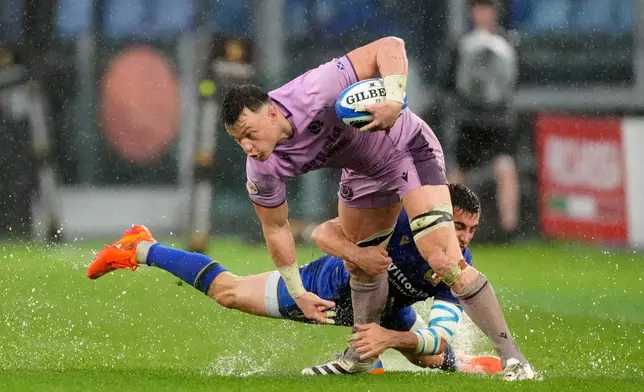 Scotland's Jack Dempsey, front, is tackled by Italy's Alessandro Fusco during the Six Nations rugby match between Italy and Scotland at Rome's Olympic Stadium, Saturday, Feb. 7, 2026. (AP Photo/Gregorio Borgia)