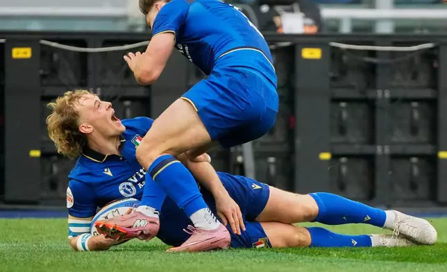 Italy's Louis Lynagh rejoices with teammate Leonardo Marin, right, after scoring a try during the Six Nations rugby match between Italy and Scotland at Rome's Olympic Stadium, Saturday, Feb. 7, 2026. (AP Photo/Gregorio Borgia)
