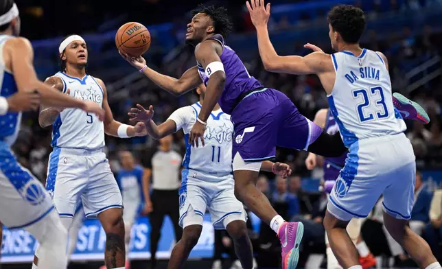Utah Jazz guard Isaiah Collier (8) shoots after being fouled by Orlando Magic guard Jase Richardson (11) as forward Paolo Banchero (5) and forward Tristan da Silva (23) look on during the first half of an NBA basketball game, Saturday, Feb. 7, 2026, in Orlando, Fla. (AP Photo/Phelan M. Ebenhack)