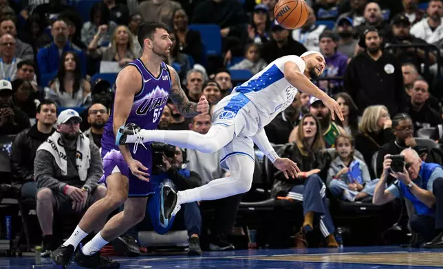 Orlando Magic guard Jalen Suggs (4) loses control of the ball as Utah Jazz forward John Konchar (55) defends during the first half of an NBA basketball game, Saturday, Feb. 7, 2026, in Orlando, Fla. (AP Photo/Phelan M. Ebenhack)