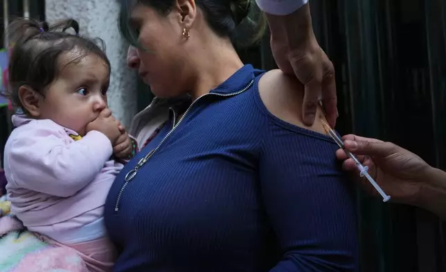 A health worker administers a dose of the measles vaccine outside a public hospital in Mexico City, Wednesday, Feb. 4, 2026. (AP Photo/Marco Ugarte)