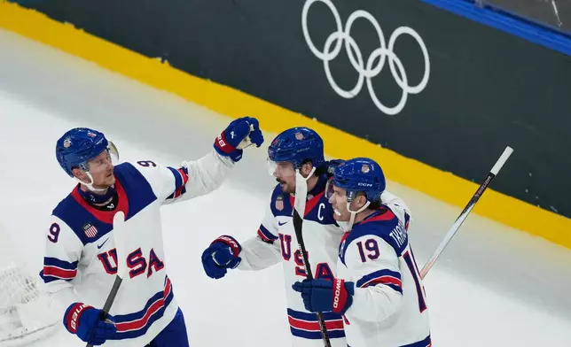 United States' Auston Matthews, center, celebrates with teammates after scoring his sides fifth goal during a preliminary round match of men's ice hockey between Latvia and the United States at the 2026 Winter Olympics, in Milan, Italy, Thursday, Feb. 12, 2026. (AP Photo/Carolyn Kaster)