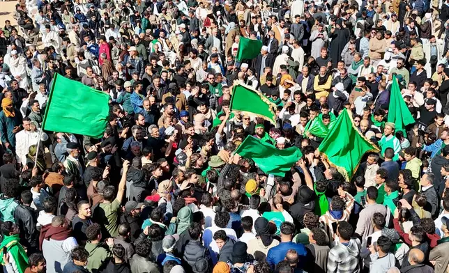 Thousands of Libyans crowd to attend the funeral of Seif al-Islam, son of former Libyan Leader Moammar Gadhafi, as they wave plain green flags, Libya's official flag from 1977 to 2011 under Gadhafi, in Bani Walid, 146 kilometers (91 miles) southeast of the capital, Tripoli, Libya, Friday, Feb. 6, 2026. (AP Photo/Yousef Murad)