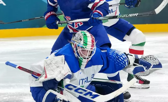Italy's goalkeeper Gabriella Durante reaches for the puck as United States' Hannah Bilka (23) and Italy's Franziska Stocker (18) close in during the second period of a women's ice hockey quarterfinal match at the 2026 Winter Olympics, in Milan, Italy, Friday, Feb. 13, 2026. (AP Photo/Carolyn Kaster)